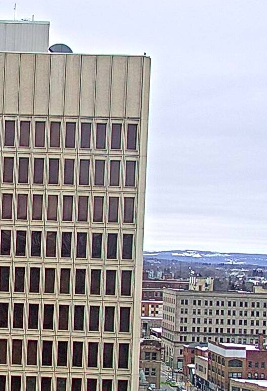 Astrid is just a tiny figure at the top corning of the Sate Building